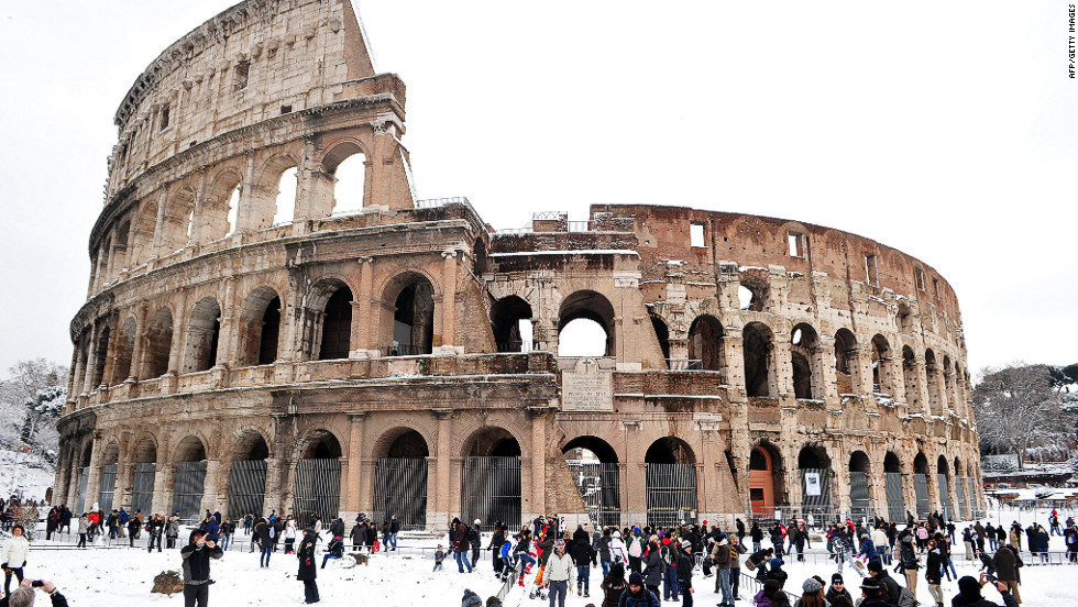 People stand in snow Saturday in front of the Colosseum in Rome.