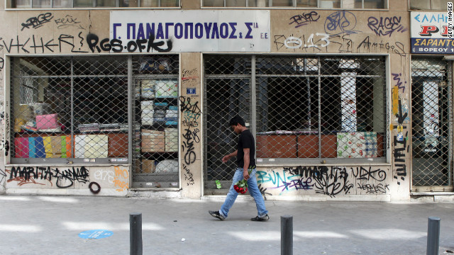 A man passes a closed shop in the city centre on May 29, 2011 in Athens, Greece. The Greek government is trying to implement a further round of severe austerity measures after EU finance officials have argued that country, which is already struggling to meet the terms of an international euro110 billion bailout - could require even more help.