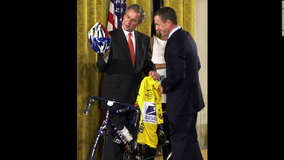 After winning the 2001 Tour de France, Armstrong presents President George W. Bush with a U.S. Postal Service yellow jersey and a replica of the bike he used to win the race.