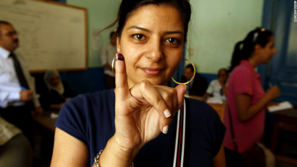 An Egyptian woman holds up an ink-stained finger after casting her vote at a polling station in Cairo.