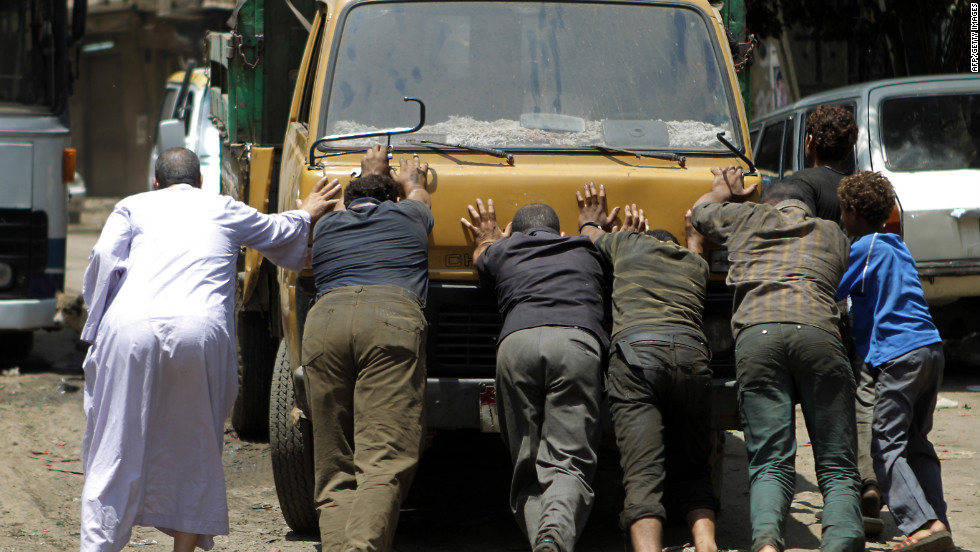 Egyptians push a truck that was blocking the entrance of a polling station.