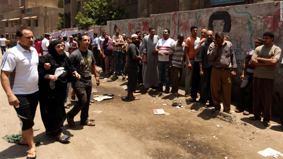 Egyptian Christian Coptic men help a woman reach a polling station in the Cairo Coptic Shubra neighborhood on Saturday, June 16.  Voters returned to the polls after Egypt&#39;s Supreme Constitutional Court ruled Thursday that the Islamist-led Parliament must be immediately dissolved.