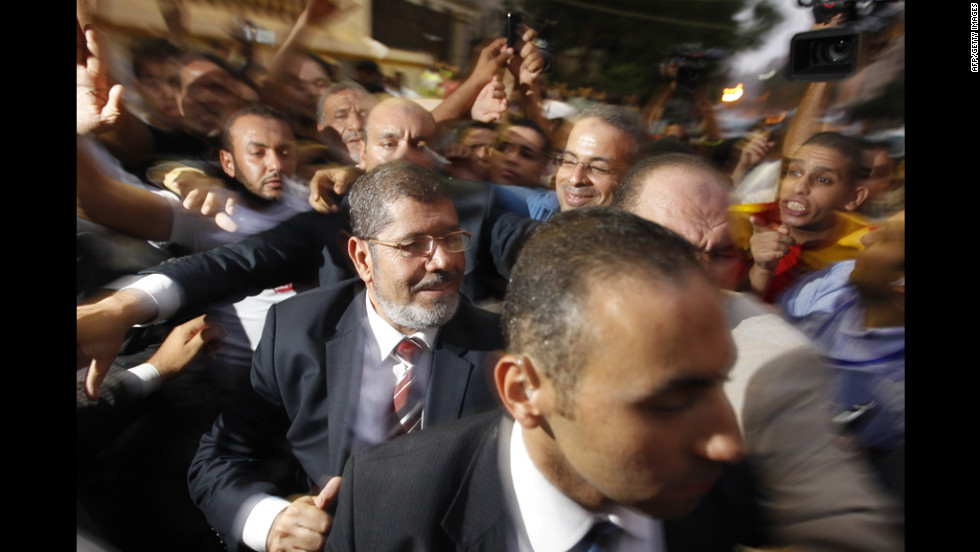 The Muslim Brotherhood&#39;s Mohamed Morsi makes his way through supporters at electoral headquarters early Monday in Cairo. In a victory speech, Morsi did not address the military council&#39;s move but tried to allay fears he would impose an Islamist state.