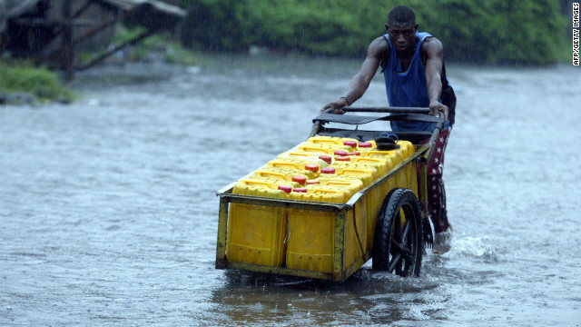 Um homem de Lagos luta contra as fortes chuvas de 2012. 