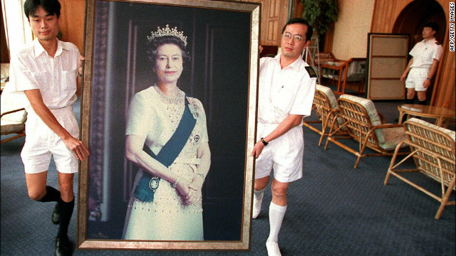 Two Royal Navy sailors carry a portrait of Queen Elizabeth through the British Forces&#39; Hong Kong headquarters as her pictures are taken down ahead of the handover of Hong Kong in 1997.