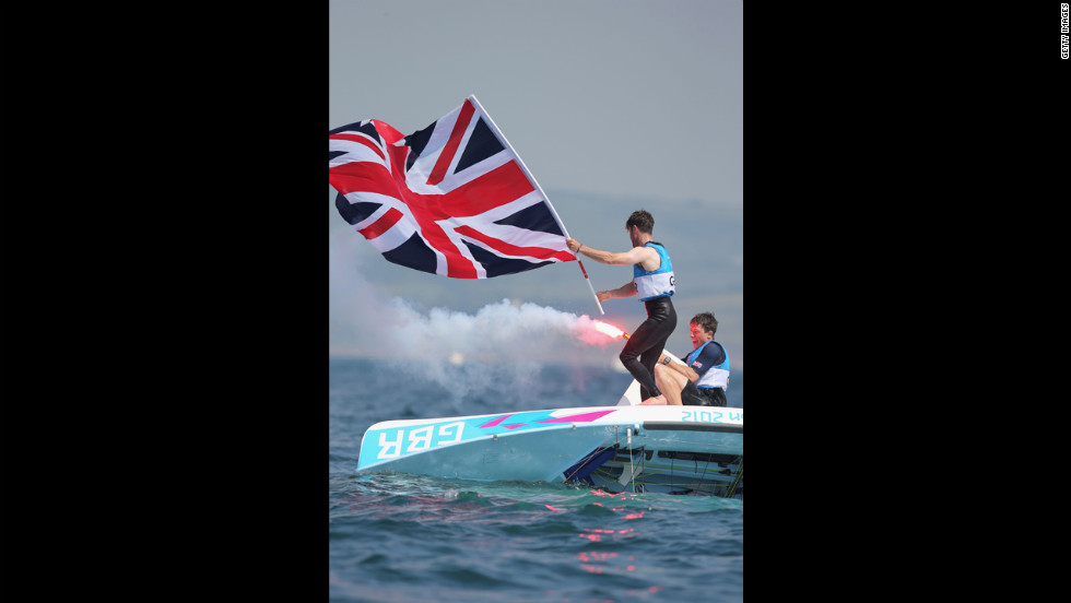 Luke Patience, left, and Stuart Bithell, right, of Great Britain let off flares as they celebrate finishing second and winning the silver medal in the men's 470 sailing.