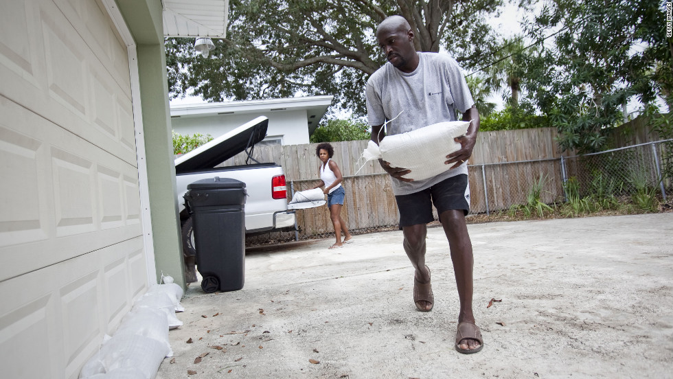 Earl, right, and Terri Harris place sandbags around their home to prepare for possible flooding.