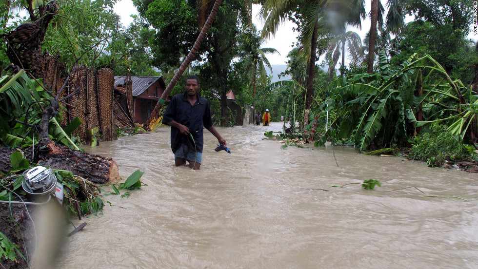 Residents of Jacmel, Haiti, make their way through floodwaters as Tropical Storm Isaac dumps heavy rains in August 2012. An extreme exposure to climate-related events, combined with poor health care access, weak infrastructure, high levels of poverty and an over-reliance on agriculture have led to the country being categorized as at &quot;extreme&quot; risk.
