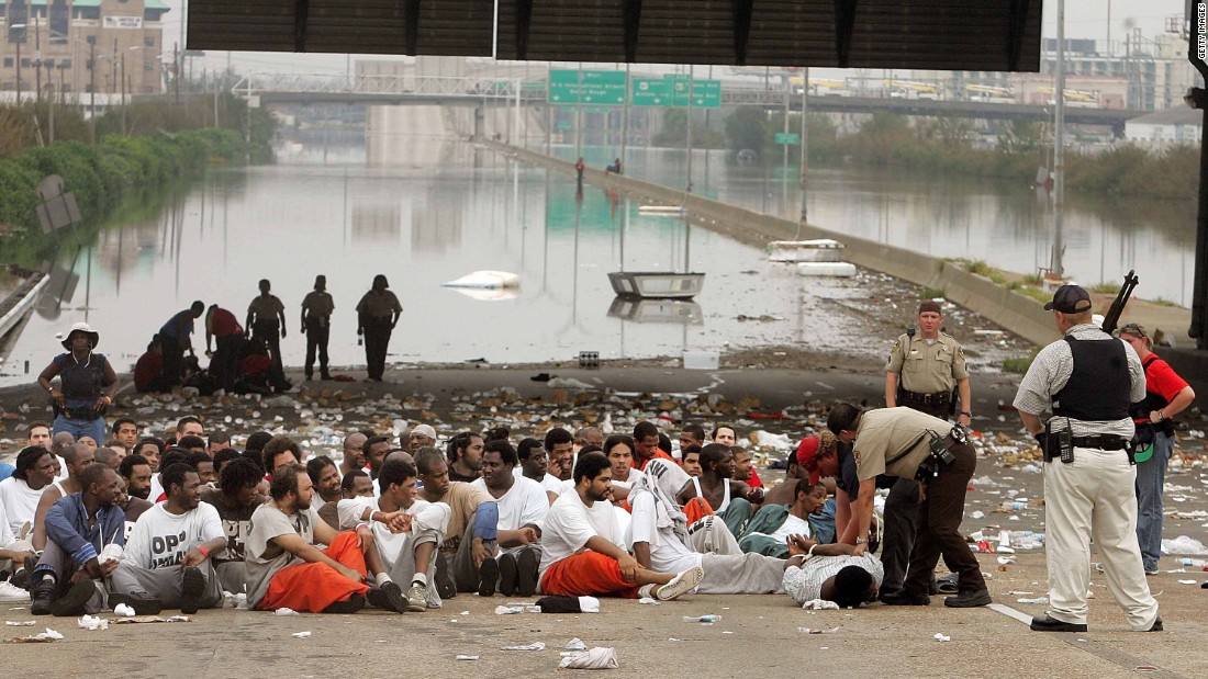 Police watch over prisoners from Orleans Parish Prison who were evacuated to a highway on September 1, 2005.