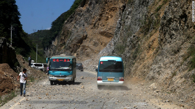 Two buses make their way across a road full of fallen rocks after a series of earthquakes, one of them measuring magnitude 5.7, hit the area near Zhaotong municipality at the border of southwest China's Yunnan and Guizhou province on September 7, 2012. The US Geological Survey put the magnitude of the largest quake at 5.6 and said it struck at a depth of 10 kilometres, with the office of China Earthquake Administration announcing that around 20 persons were injured and six had died. CHINA OUT AFP PHOTO (Photo credit should read STR/AFP/GettyImages) 