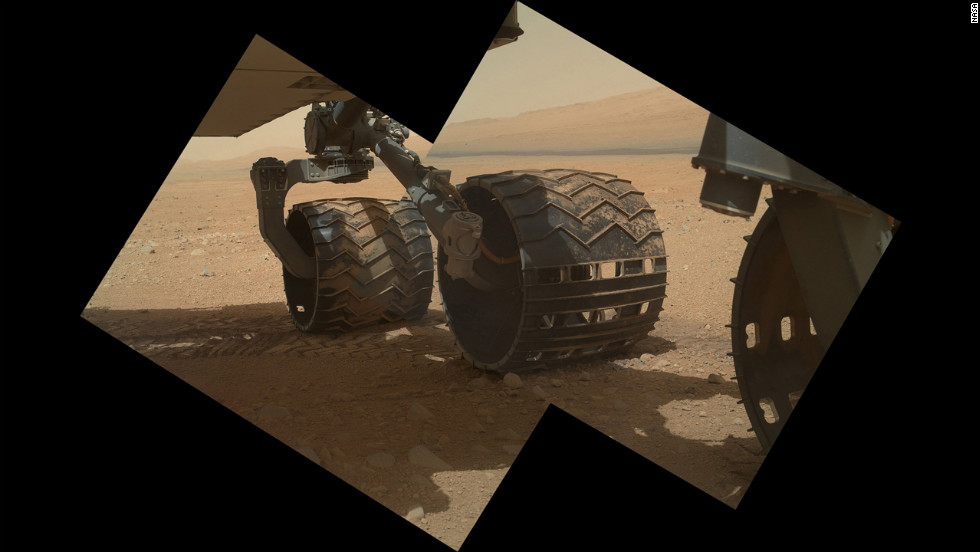 This view of the three left wheels of NASA&#39;s Mars rover Curiosity combines two images that were taken by the rover&#39;s Mars Hand Lens Imager on September 9, 2012, the 34th day of Curiosity&#39;s work on Mars. In the distance is the lower slope of &quot;Mount Sharp.&quot;