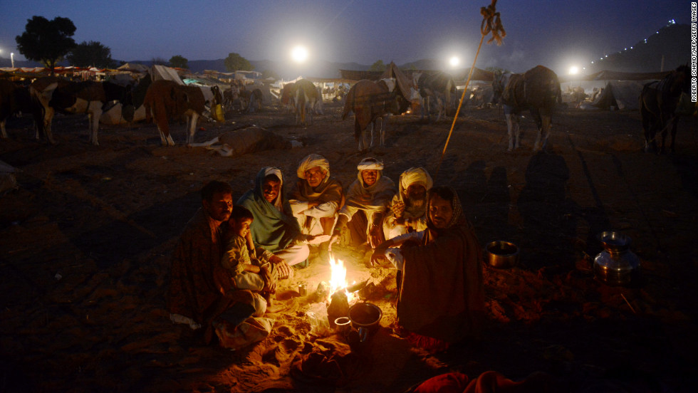 A group of camel traders sit around a fire in the early morning hours on Wednesday.