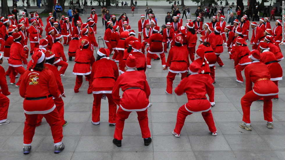 Members of a local yoga club perform at a public park wearing Santa Claus costumes in Hanoi, Vietnam, on December 23.