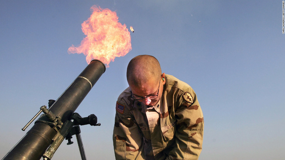 Spc. Franklin Smith pulls away as a mortar blast is fired from the edge of the U.S. airbase in Tal Afar on January 17, 2005. U.S. teams would frequently fire &quot;harassment and interdiction&quot; mortar fusillades toward suspected enemy positions.