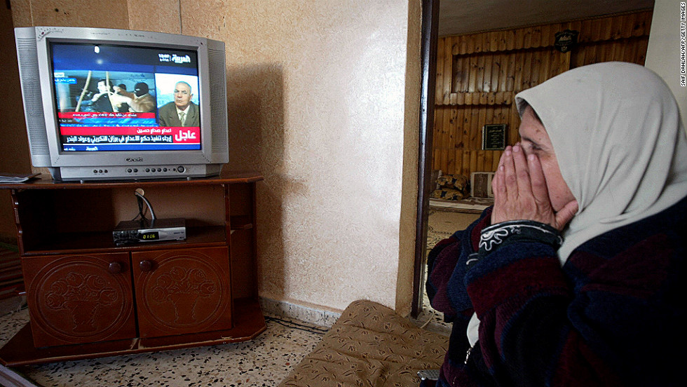 A Palestinian woman watches the news of Saddam Hussein&#39;s execution at her home in the West Bank town of Jenin on December 30, 2006. Hussein was hanged for his role in the 1982 Dujail massacre, in which 148 Iraqis were killed after a failed assassination attempt against the then-president.