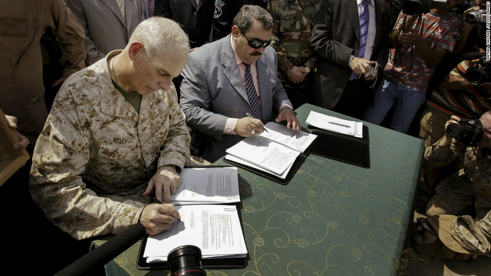 Maj. Gen. John Kelly, left, and Anbar province Gov. Maamoun Sami Rashid al-Alwani sign papers during a handover ceremony in Ramadi on September 1, 2008. The U.S. military turned over security control of Iraq&#39;s biggest province, once a stronghold of the Sunni insurgency.