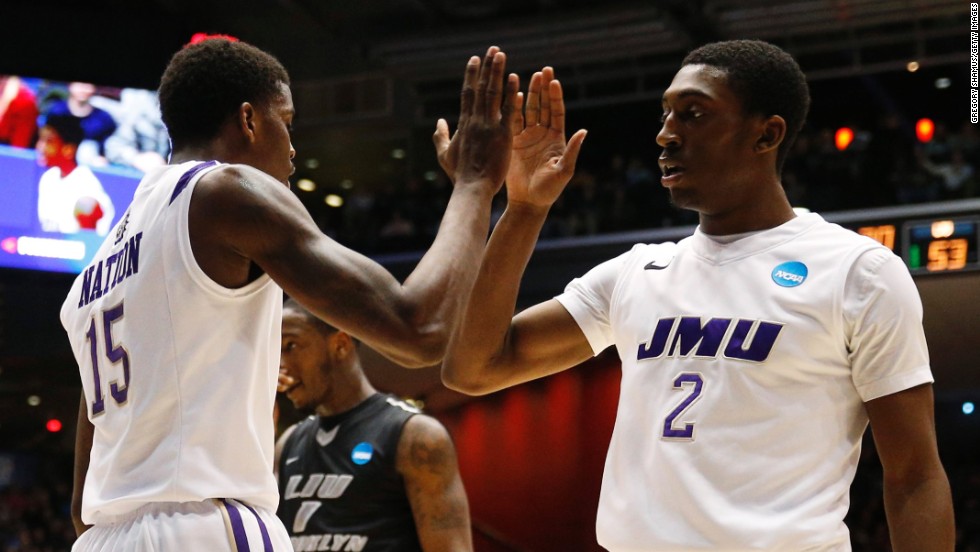 Ron Curry and Andre Nation of the James Madison Dukes celebrate as time winds down against LIU Brooklyn on March 20.