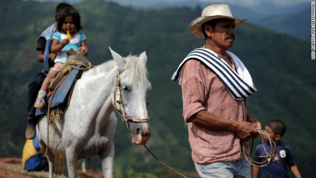 A farmer leads his horse with his children mounted on it on a hill in Calandaima, rural area of Miranda, department of Cauca, Colombia, on June 28, 2012. 