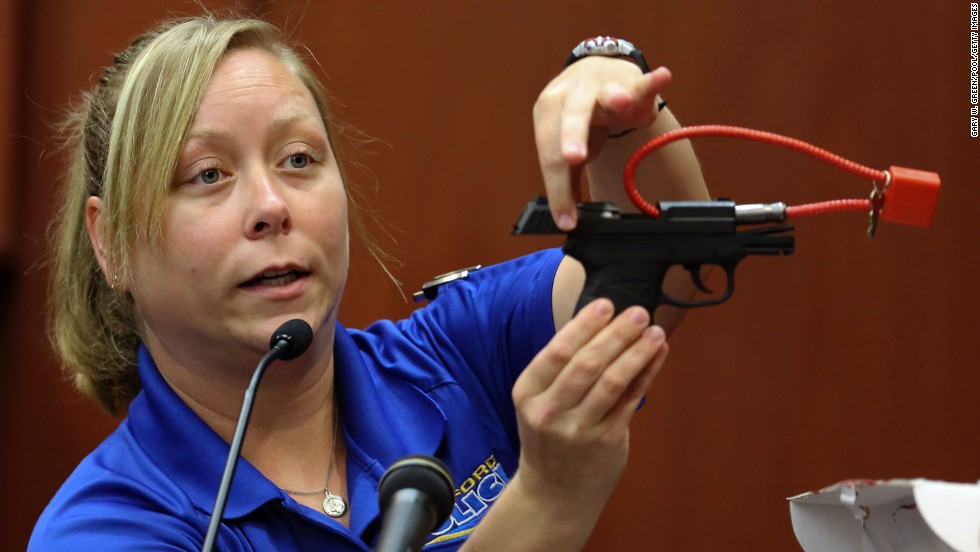 During the trial on June 25, crime scene technician Diana Smith shows the jury a gun that was collected as evidence.