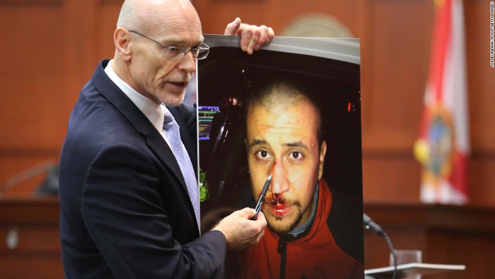 Defense attorney Don West displays a photo of Zimmerman from the night of the shooting during his opening arguments on June 24. He opened his statements with a knock-knock joke but failed to win a laugh. &quot;Knock knock. Who&#39;s there? George Zimmerman. George Zimmerman who? Good, you&#39;re on the jury,&quot; he said.
