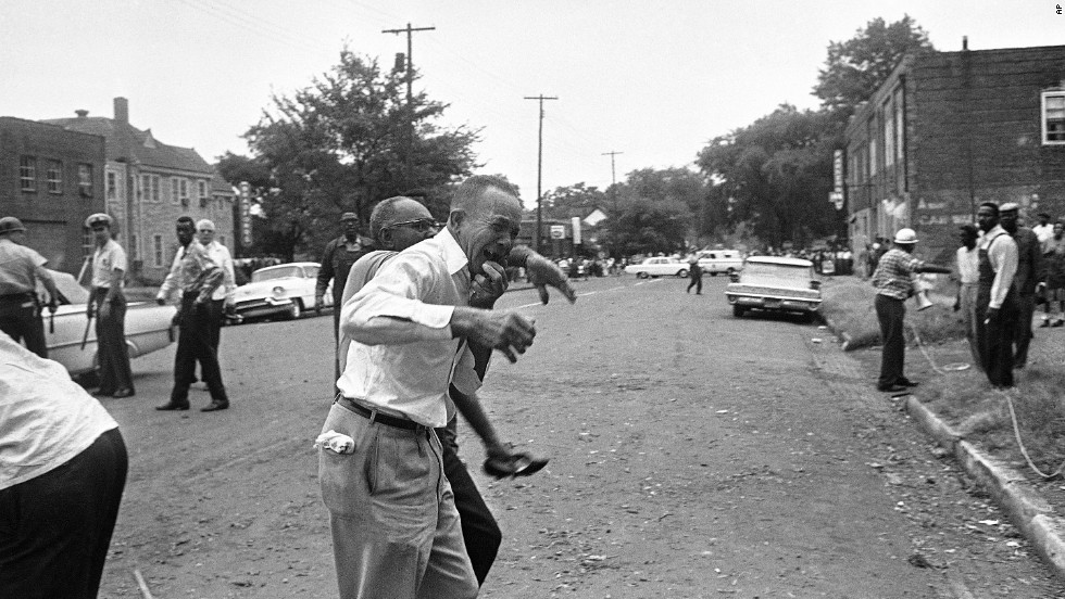 A grieving relative is led away from the site of the &lt;a href =&quot;http://www.cnn.com/2013/06/13/us/1963-birmingham-church-bombing-fast-facts/index.html&quot;&gt;16th Street Baptist Church bombing&ampltt;/A&gt; バーミンガムで, アラバマ, 9月に 15, 1963. Four black girls were killed and at least 14 他の人が負傷した, sparking riots and a national outcry.