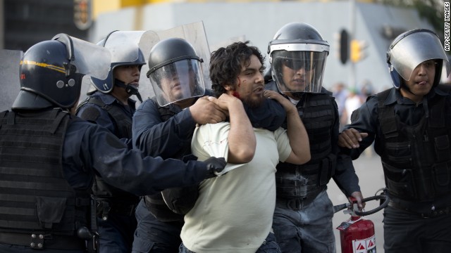 Riot police arrest a demonstrator in Mexico City on October 2, 2013. Mexican students marched Wednesday to commemorate the anniversary of the Tlatelolco massacre of university students. AFP PHOTO/ YURI CORTEZ (Photo credit should read YURI CORTEZ/AFP/Getty Images)

