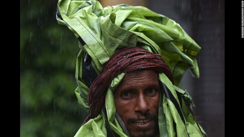 An Indian rickshaw puller covered with plastic walks through a street during the heavy rains in Kolkata, India, on Saturday, October 26. Earlier this month, a cyclone struck the eastern coast and is now involved with mass flooding that has forced thousands to flee their homes and seek refuge in shelters.
