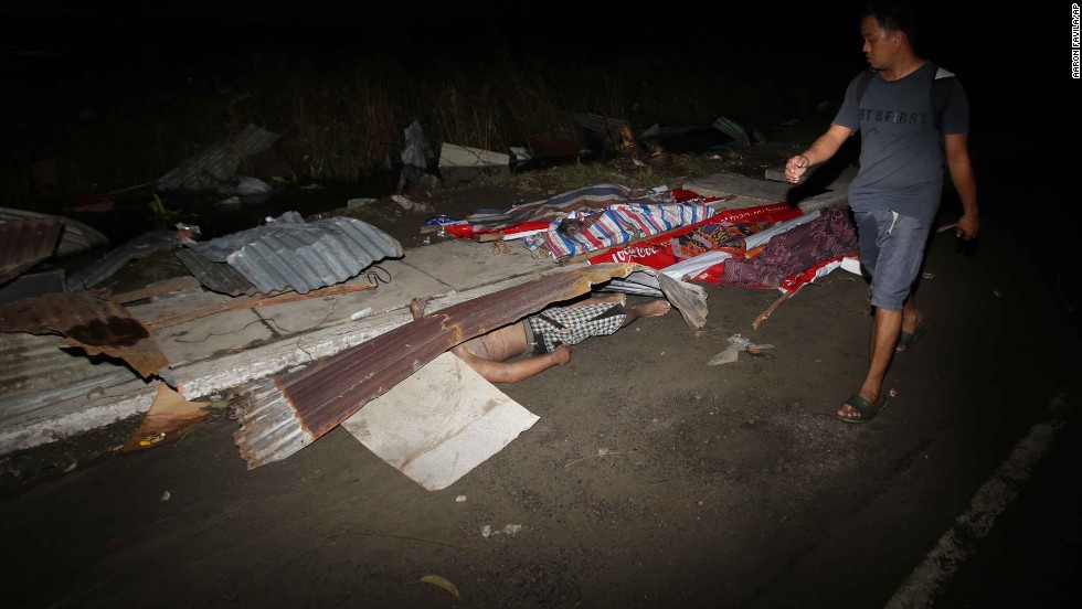 A resident passes victims&#39; bodies on a Tacloban street November 9.