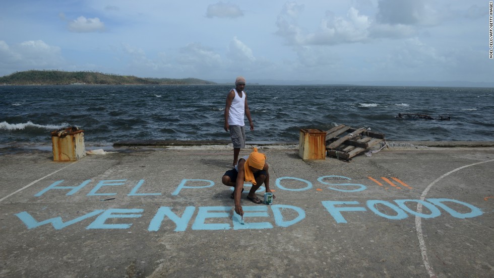 A man seeking aid paints a message on a basketball court November 11 in Anibong, Philippines.