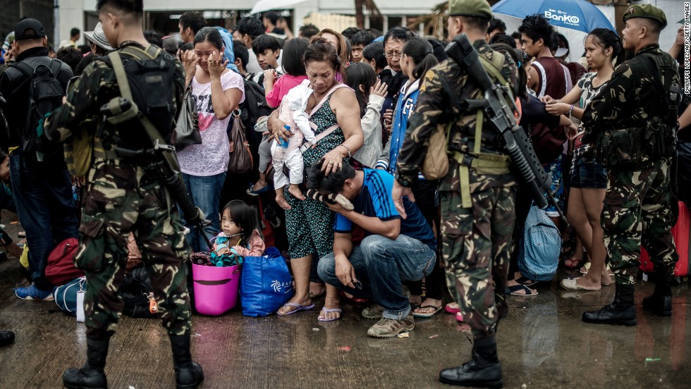 A woman comforts a crying relative as a plane leaves the Tacloban airport November 12.