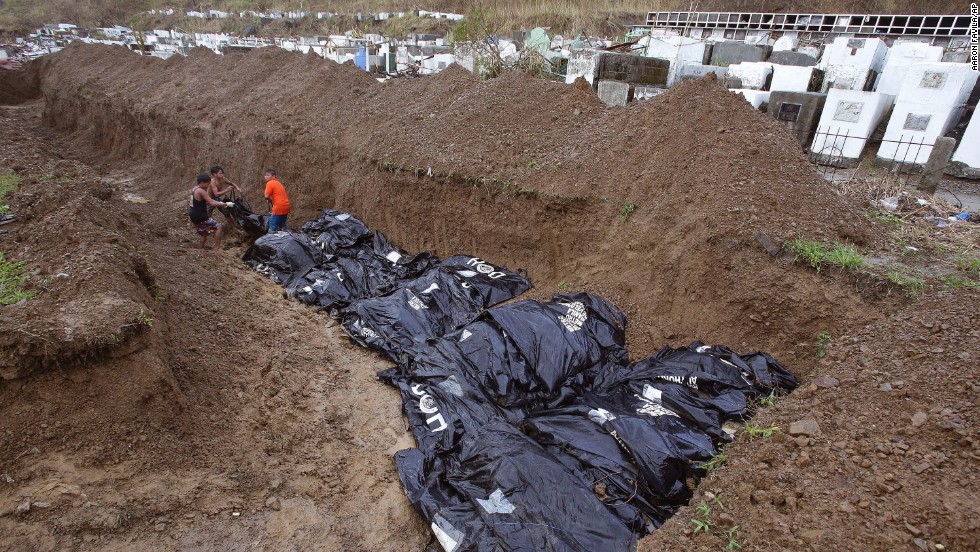Workers arrange bodies at a mass burial site at a Tacloban cemetery November 14.