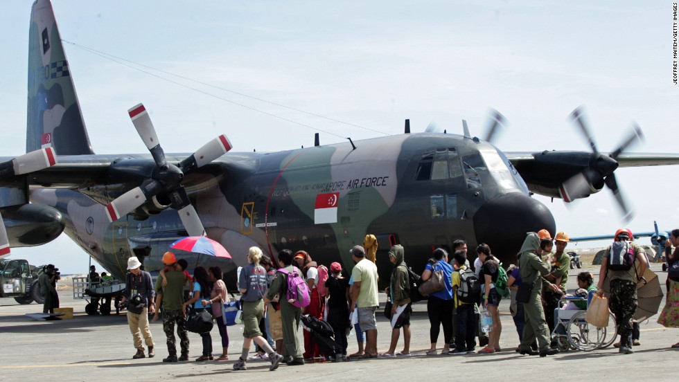 Residents wait to board a Singaporean cargo plane at the Tacloban airport on November 15. Many survivors have converged on the city&#39;s airport to wait for flights.