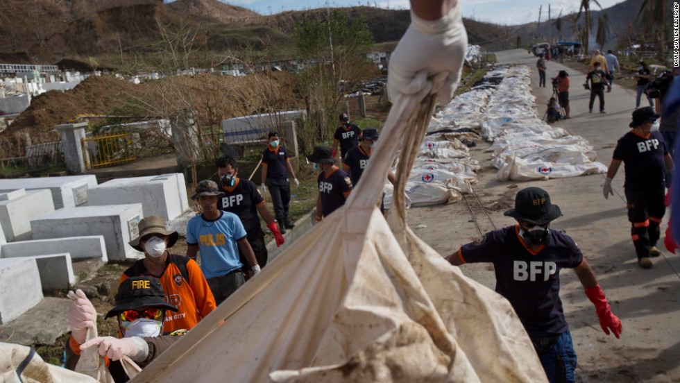 Firemen unload bodies November 19 for forensic experts to register and bury in a mass grave outside of Tacloban.