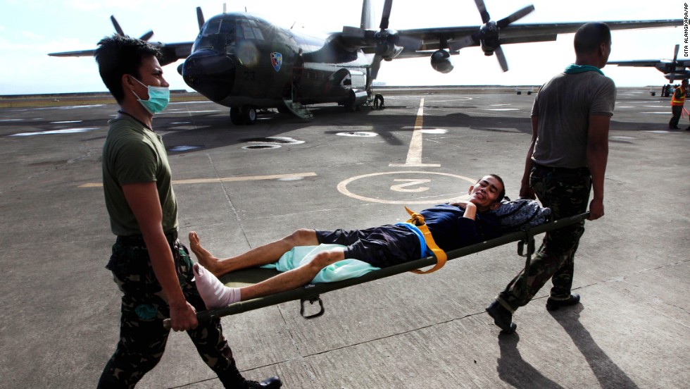 Philippine military personnel carry an injured survivor to an evacuation flight at the Tacloban airport November 19.
