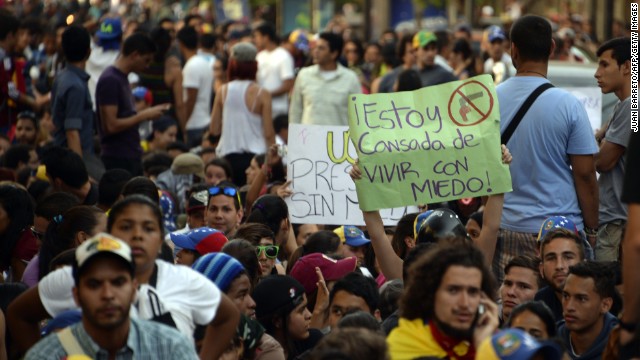 Students sit on the street as a protest against the death of a student who was killed on the eve during a demonstration against the government of Venezuelan President Nicolas Maduro, in Caracas, on February 13, 2014.
