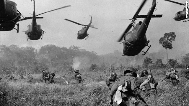 FILE - In this March 1965 file photo shot by Associated Press photographer Horst Faas, hovering U.S. Army helicopters pour machine gun fire into the tree line to cover the advance of South Vietnamese ground troops in an attack on a Viet Cong camp 18 miles north of Tay Ninh, Vietnam, northwest of Saigon near the Cambodian border.  (AP Photo/Horst Faas, File)
