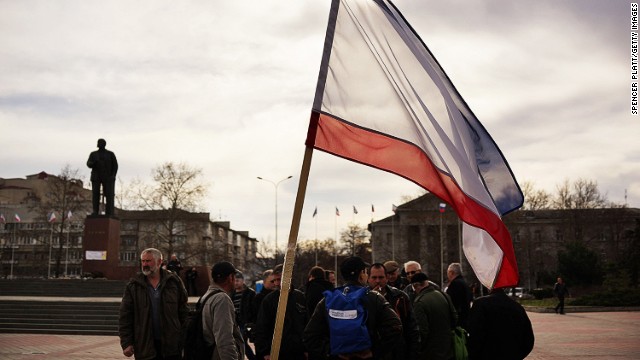 Members of a pro Russian volunteer force gather in formation next to a statue of Lenin and the Crimean flag on March 6, 2014 in Simferopol, Ukraine.