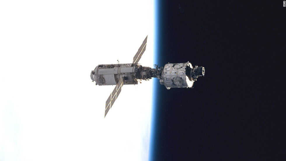 The Zarya control module, on the left with the solar panels, floats above Earth with its newly attached Unity module after the first assembly sequence in December 1998.