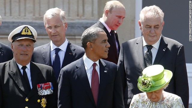 Russian President Vladimir Putin (C top) passes behind US President Barack Obama (C), Britain's Queen Elizabeth (bottom R), Norway's King Harald (L) and King Philippe of Belgium (L top) as he arrives for a group photo for the 70th anniversary of the D-Day landings at Benouville Castle, June 6, 2014.