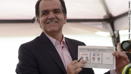 Colombian presidential candidate for the Democratic Center party, Oscar Ivan Zuluaga, casts his vote during the presidential runoff election, in Bogota, on June 15, 2014. Colombians went to the polls Sunday in a cliffhanger presidential election that has become a referendum on peace talks with leftist guerrillas. Voters will choose between President Juan Manuel Santos, who is seeking a second term, and Oscar Ivan Zuluaga, a vehement critic of the president's peace talks with the Revolutionary Armed Forces of Colombia (FARC). AFP PHOTO/Raul ARBOLEDA (Photo credit should read RAUL ARBOLEDA/AFP/Getty Images)