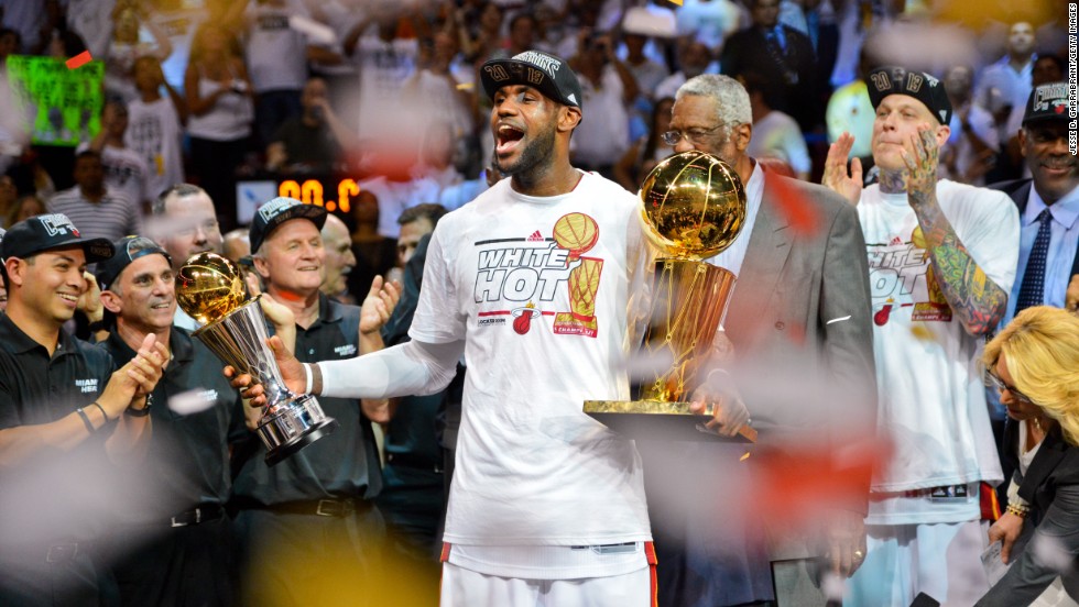 James holds the Finals MVP trophy and the Larry O&#39;Brien Championship trophy after the Heat defeated the San Antonio Spurs to win back-to-back titles in June 2013.