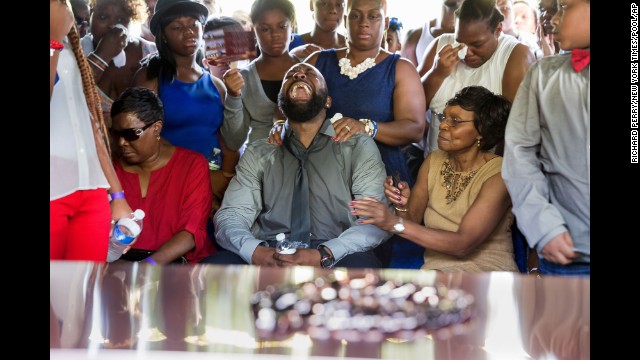 Michael Brown Sr., yells out as the casket holding the body of his son, Michael Brown, is lowered into the ground during the funeral service in Normandy, Missouri, on Monday, August 25.