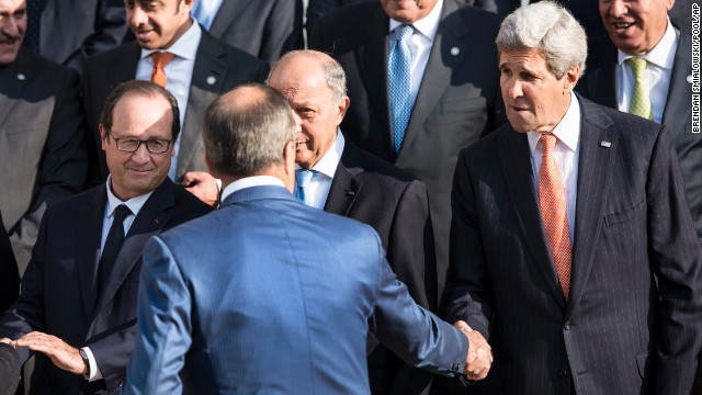 French President Francois Hollande, left,  watches U.S Secretary of State John Kerry, right, shaking hands with Russian Foreign Minister  Sergey Lavrov, back to the camera, before a family photo at the international conference intended to come up with an international strategy against  Islamic State extremists, in Paris, Monday, Sept. 15, 2014. As diplomats from around the world sought a global strategy to fight Islamic State extremists, Iran ruled out working with any international coalition, saying it had rejected American requests for cooperation against the militants. Partially hidden at center is French Foreign Minister Laurent Fabius. (AP Photo/Brendan Smialowski; Pool)