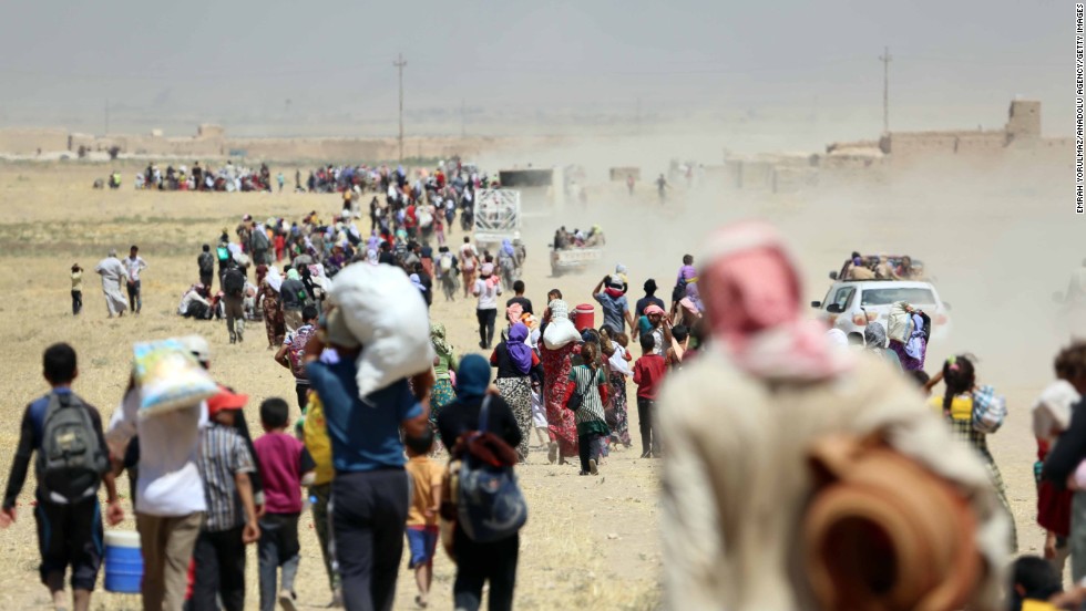 Thousands of Yazidis are escorted to safety by Kurdish Peshmerga forces and a People&#39;s Protection Unit in Mosul on Saturday, August 9.