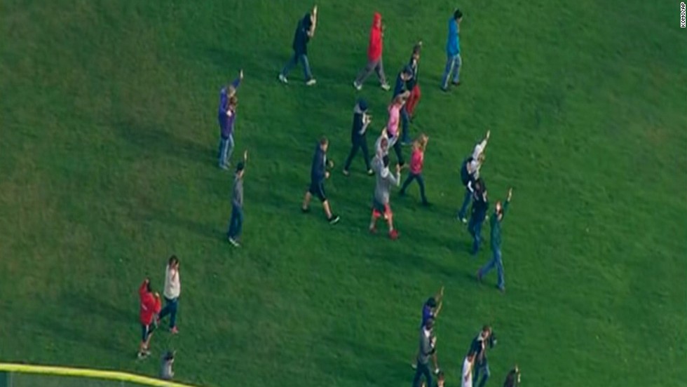 Students walk across a field after reports of shots being fired at the school.