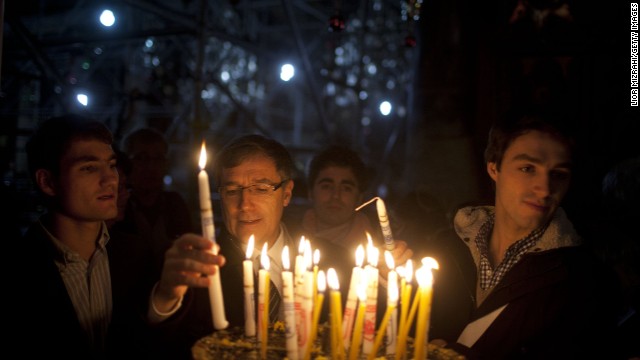 BETHLEHEM, WEST BANK - DECEMBER 24: Visitors light candles in the Church of the Nativity on December 24, 2014 in Bethlehem, West Bank. Every Christmas pilgrims travel to the church where a gold star embedded in the floor marks the spot where Jesus was believed to have been born. (Photo by Lior Mizrahi/Getty Images)