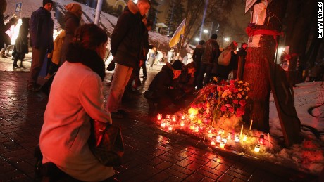 KIEV, UKRAINE - FEBRUARY 20: Women kneel at a memorial to Nazar Voytovich, one of the many victims of the Maidan uprising one year ago, following an evening ceremony and concert of Mozart&#39;s &quot;Requiem&quot; attended by tens of thousands at Maidan square on February 20, 2015 in Kiev, Ukraine. Ukraine is commemorating the first anniversary of the February 20, 2014 sniper attacks that killed dozens of protesters on the Maidan and were followed by the ouster of Ukrainian President Viktor Yanukovich shortly later. Meanwhile fighting between pro-Ukrainian troops and pro-Russian separatists is continuing in the Donbas region of eastern Ukraine despite the recent Minsk ceasefire agreements. (Photo by Sean Gallup/Getty Images)