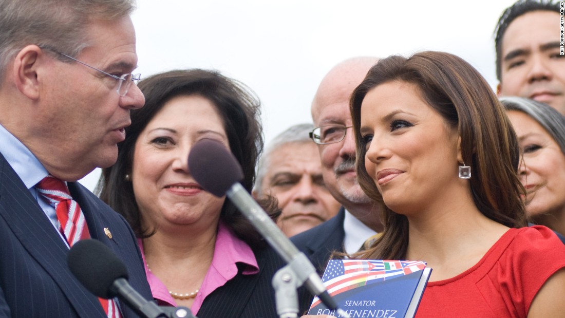 Senator Robert Menendez gives actress and activist Eva Longoria a copy of his book &#39;Growing American Roots&#39; during a National Museum of the American Latino Commission press conference at the House Triangle on October 13, 2009 in Washington, D.C.