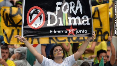A demonstrator holds a banner reading 'Dilma out and take the Workers Party with you' during a rally to protest against the government of president Dilma Rousseff in Paulista Avenue in Sao Paulo Brazil on 15 March 2015. Thousands of demonstrators clad in the yellow-green national colours protested Sunday in several cities of Brazil against president Dilma Rousseff who is facing a complex economic panorama and a political corruption scandal.