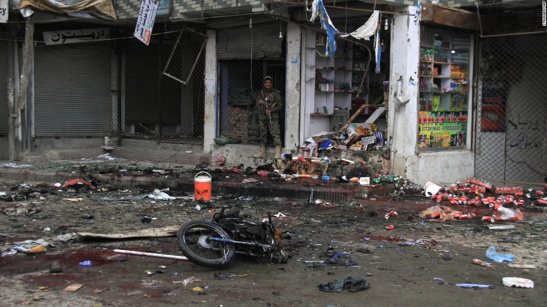 A member of Afghanistan&#39;s security forces stands at the site where a suicide bomber on a motorbike blew himself up in front of the Kabul Bank in Jalalabad, Afghanistan, on Saturday, April 18. ISIS claimed responsibility for the attack. The explosion killed at least 33 people and injured more than 100 others, a public health spokesman said.